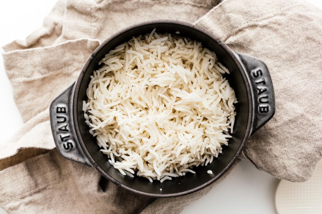 An iron vessel filled with cooked fluffy basmati rice